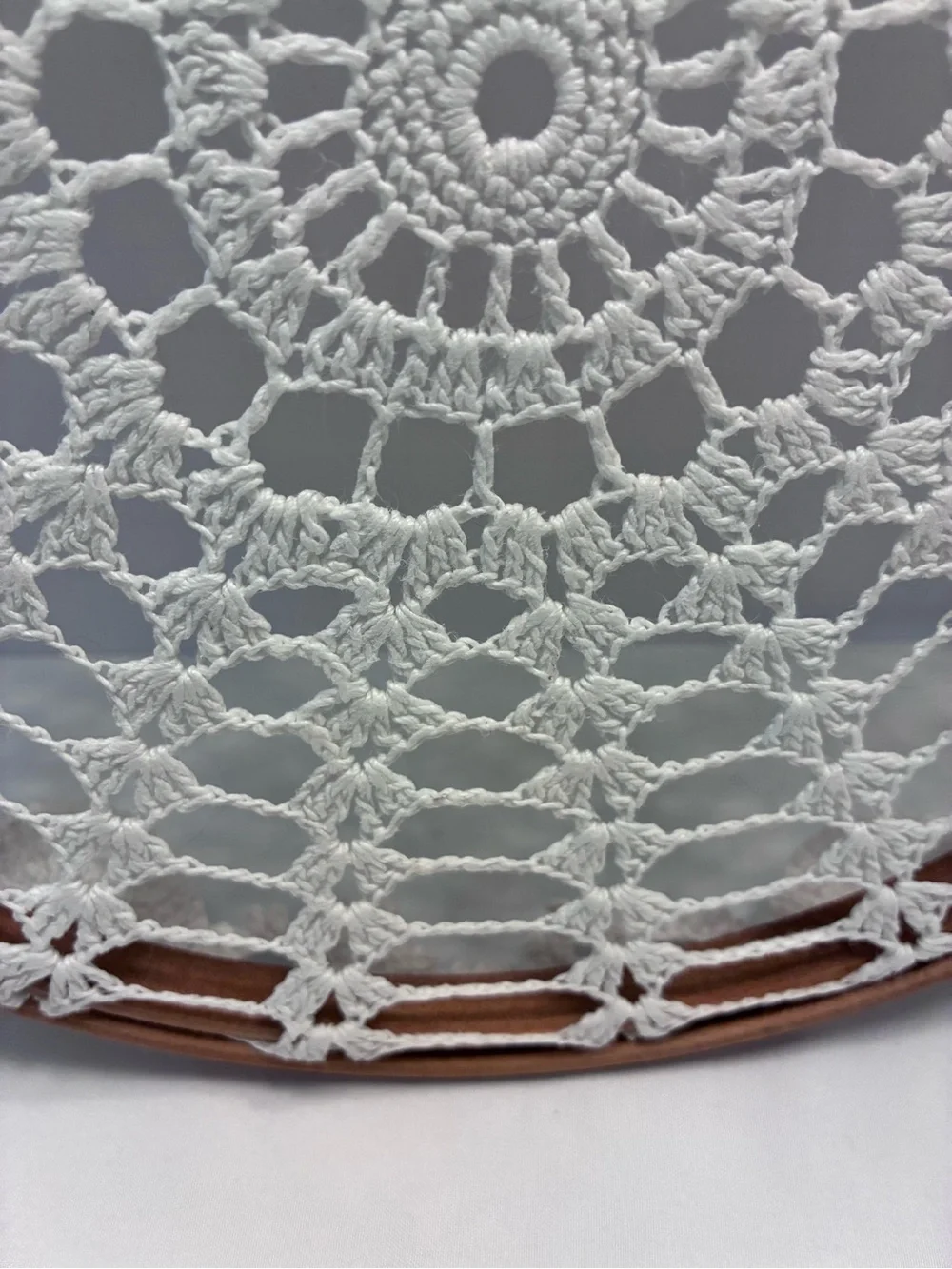 Handmade 10” crochet doily stretched inside a wooden embroidery hoop